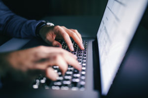 person typing on laptop