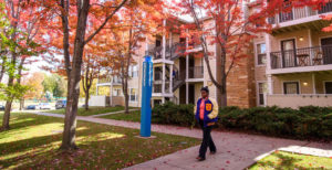 student walking through campus apartments