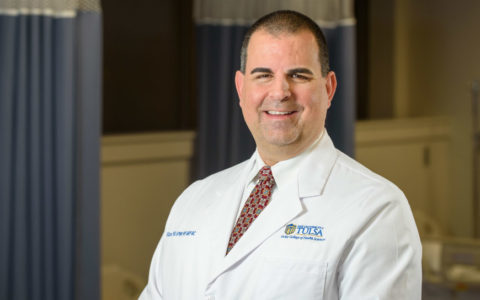 University of Tulsa School of Nursing Director Bill Buron wearing a white medical coat