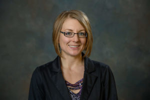 Professor Bethany Johns wearing glasses and a dark blazer