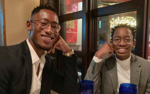 Two men in a restaurant smiling at the camera