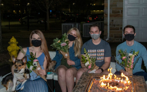 Four young people wearing face masks and holding bouquets of flowers