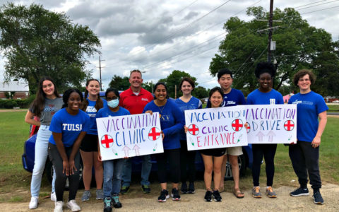 a group of people standing outdoors and holding signs