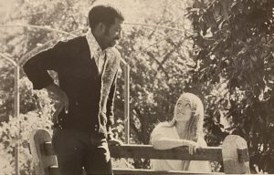 Black and white photo of two young people conversing outside