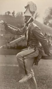 Black and white photo of a drum major marching