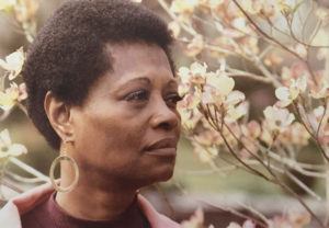 Headshot of a black woman outside in front of foliage