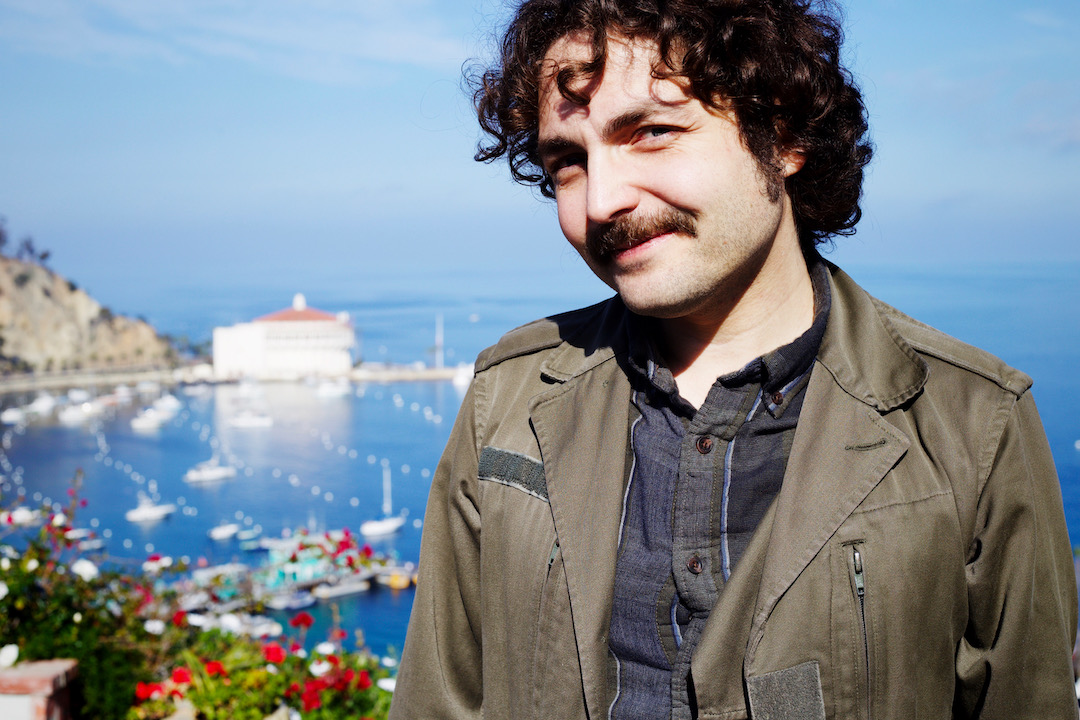 Person smiling with a harbor in the background