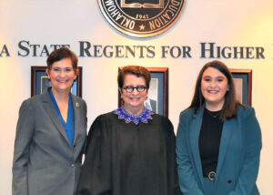 three women standing in front of signage that reads Oklahoma State Regents for Higher Education