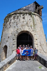People with Tulsa flag in front of stone structure
