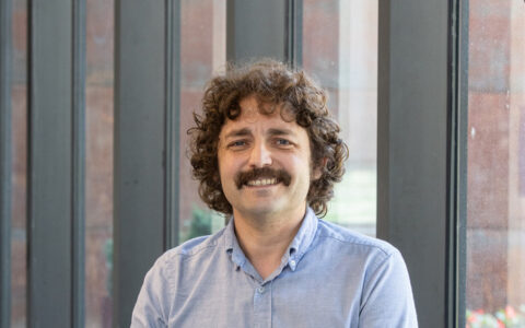 Photograph of Boris Dralyuk smiling and wearing a blue shirt