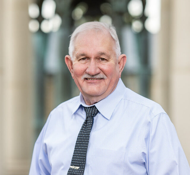 Michael Stafford, P.E., smiling in a blue striped shirt and patterned tie