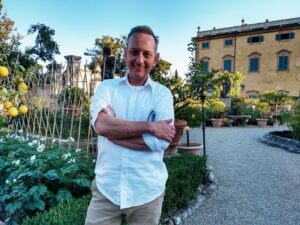 Man posing for photo in front of a garden