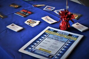 display of various colorful items on a blue tablecloth including a program for Senior Film Night
