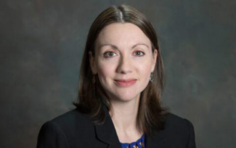 woman with long hair wearing a dark blazer