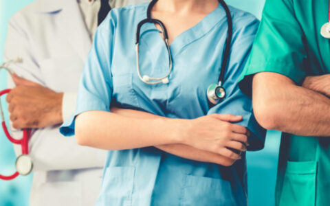 close-up shot of three people in hospital scrubs with arms crossed