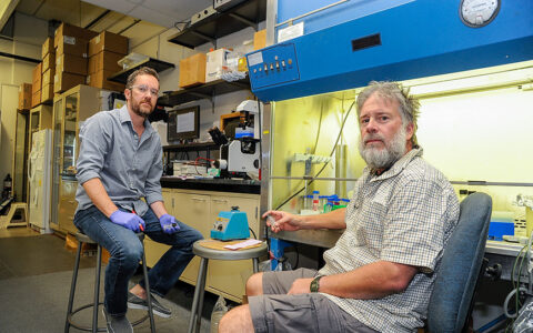 two men sitting in a science lab