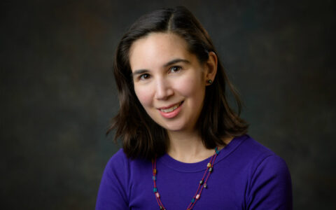 Young woman with dark hair and a purple top