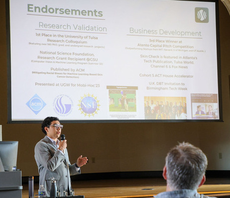 Photograph of TU student presenting in an auditorium