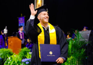 Photograph of a TU student wearing regalia at a commencement ceremony.