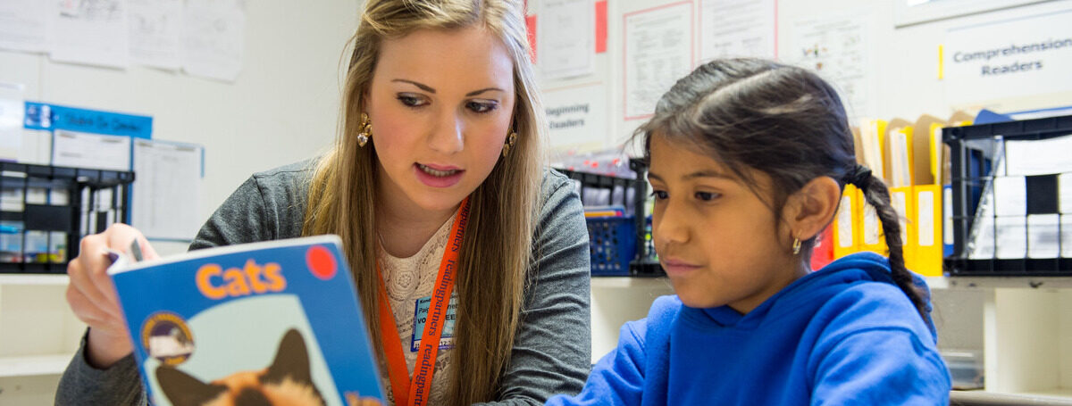 Photograph of a TU student engaging with an elementary school child