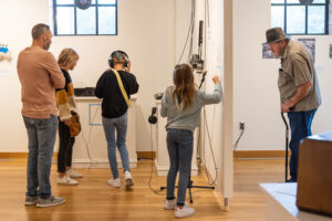 Photograph of visitors engaging with Musical Legacies of the Dust Bowl exhibition displays.