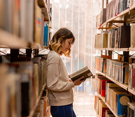 Photograph of a student reading in the library