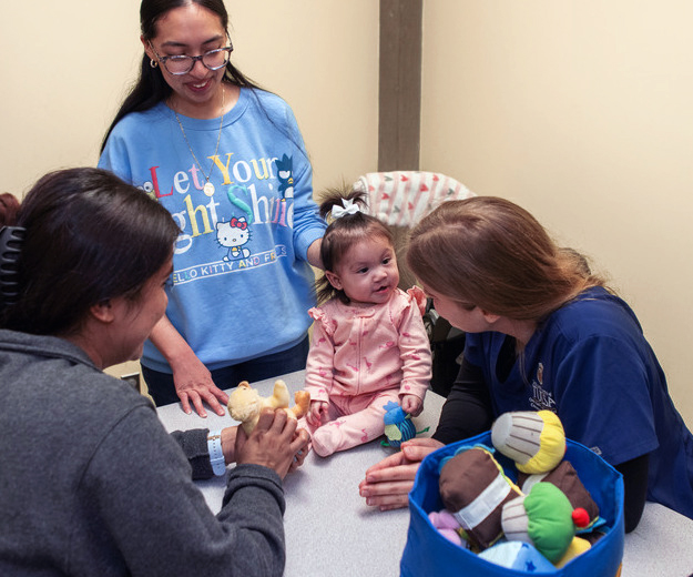 UTulsa Speech Language Pathology students and faculty with a clinic patient