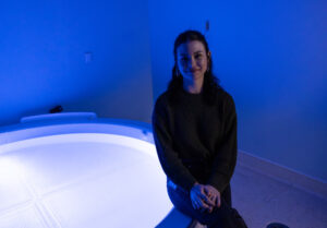 Rachel Thompson sitting and smiling in a lit room at LIBR