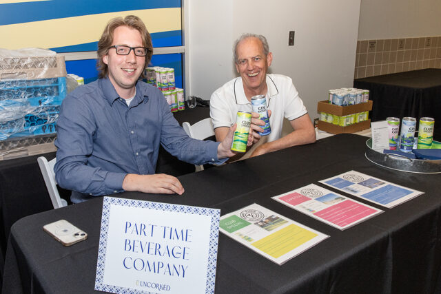 Photograph of Eric Hudkins and Dr. Bruce Hudkins sitting at a table during an event