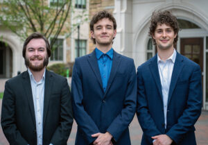 Three UTulsa students wearing business suits while standing outdoors