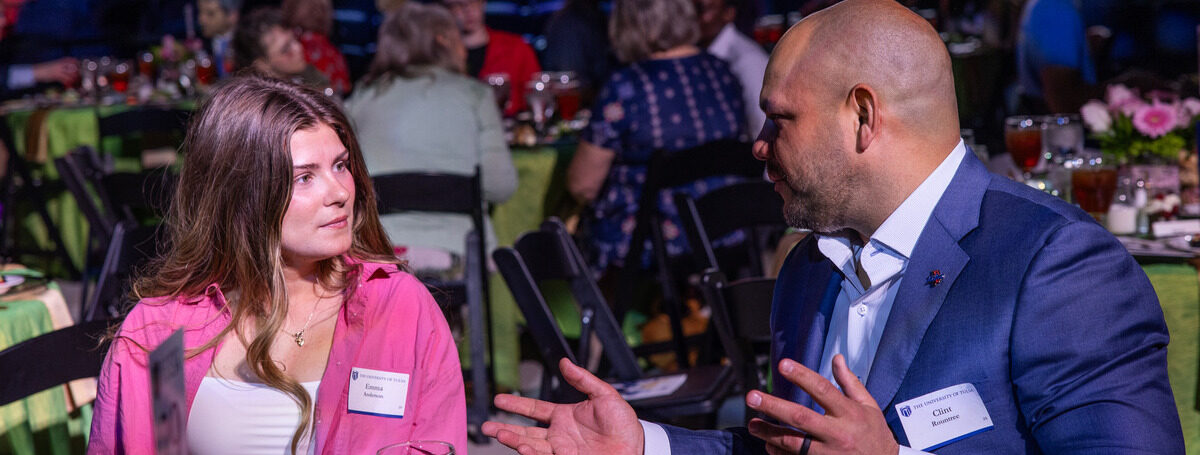 Photo of student and campus leader sitting at a table having a conversation at the scholarship luncheon