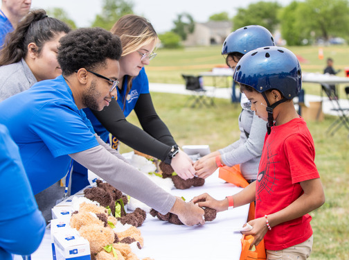 UTulsa Students at the Youth Sports Safety Festival demonstrating tips to kids who are wearing helmet
