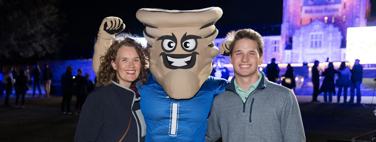 Picture of family members standing beside Gus. T