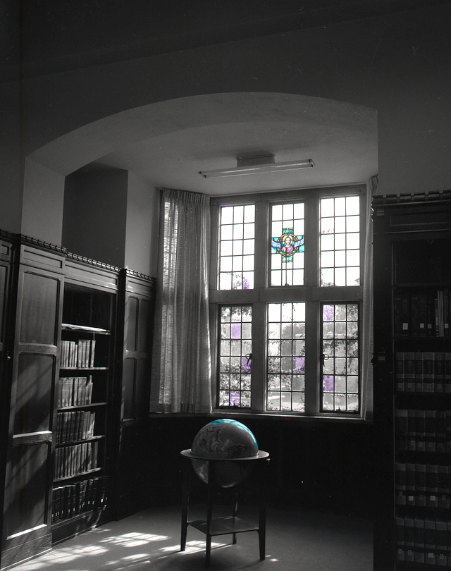 Photograph of a reading nook in McFarlin Library with a stained glass window and globe