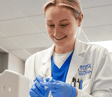 Photograph of a smiling nurse preparing a syringe