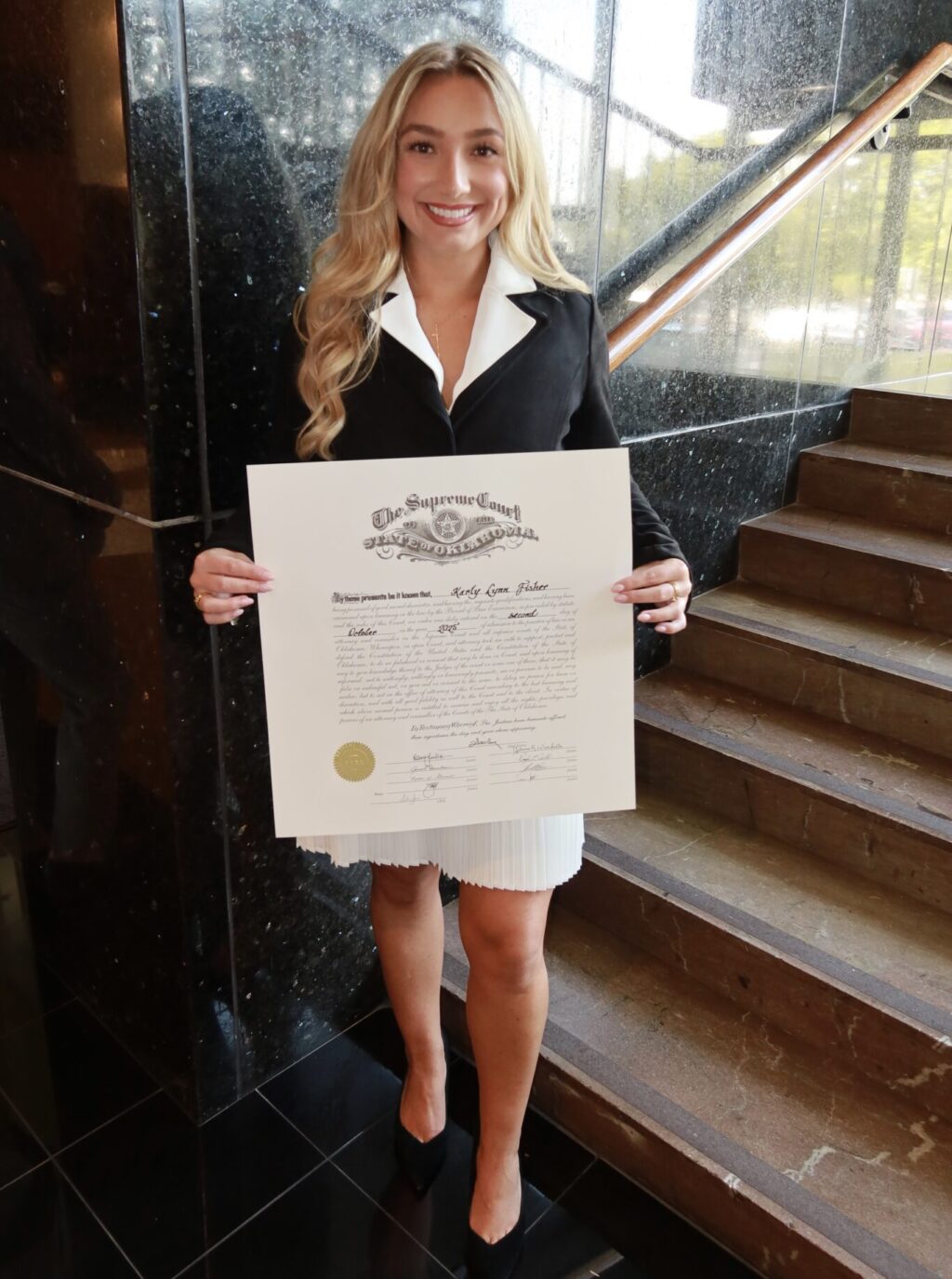 UTulsa Law alumni Karly Fisher sworn in as attorney, holding Supreme Court certificate.