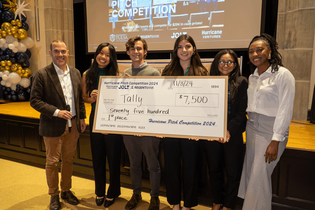 UTulsa Hurricane Pitch 2024 winners, Tally, holding a large check for $7,500 on stage.
