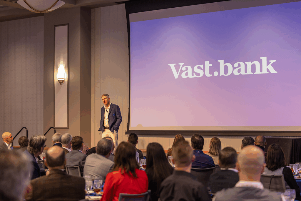 Greg Kidd speaking at Friends of Finance, Vast.bank logo on screen.