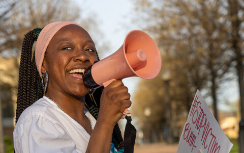 Student activist speaks into a megaphone at a Take Back the Night event.