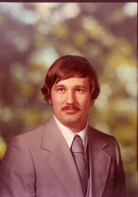 Portrait of a distinguished petroleum engineering professor in a suit.