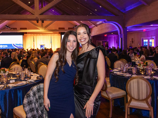 Two women at a Law Alumni Gala, dressed in formal attire, smiling for the camera.