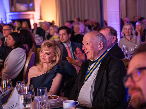 Law Alumni Gala: Attendees at a formal dinner, smiling and clapping.