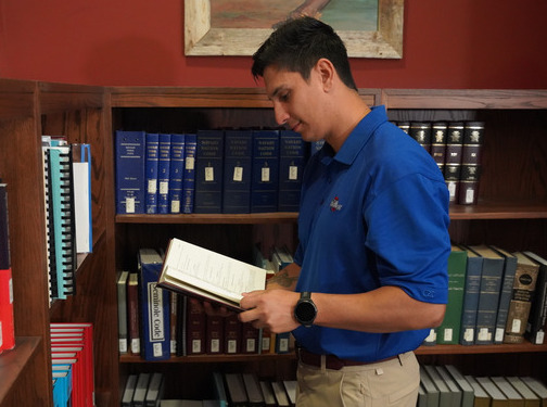 Man researches law books in the Native American Law Center library.
