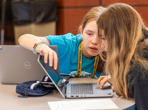 Two girls collaborating on a laptop at the Oklahoma Cyber Innovation Institute.