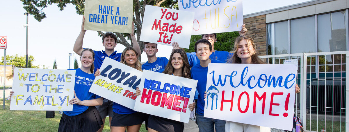 UTulsa students welcome new students with signs: "Welcome Home!", "Loyal Always Tru".