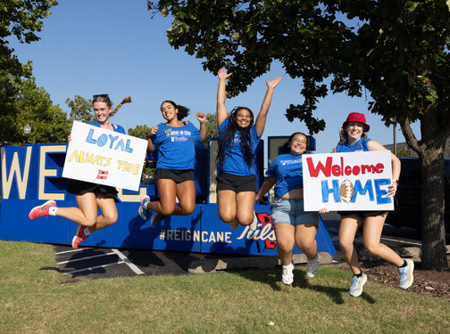 UTulsa students jumping with signs: "Loyal Always True," "Welcome Home.