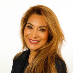 Professional headshot of a smiling woman with long brown hair. 