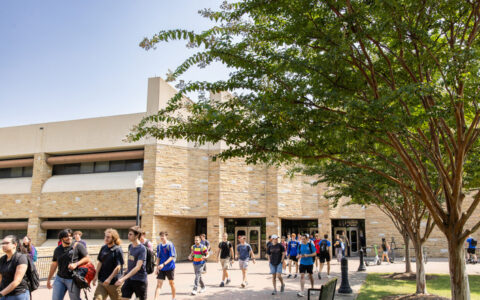 Students walking near the University of Tulsa building, possibly part of the NSF research program.