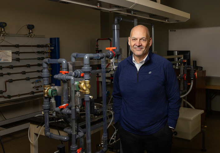 Rick Payne, leader of the Center for Energy Studies at UTulsa, stands in a lab with pipes and equipment.