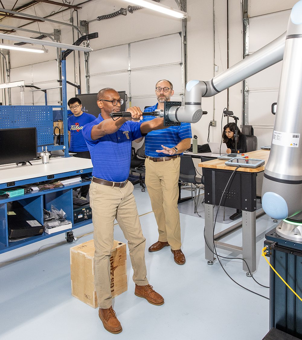 Researchers at UTulsa work with robotic arm in a research setting